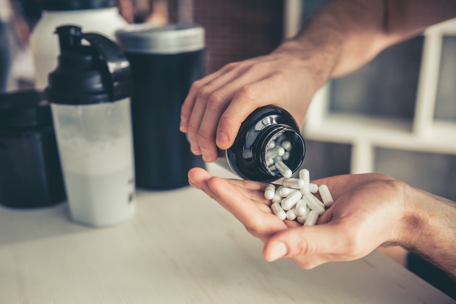 Suplementos de BCAA, hombre cargando suplementos en su mano para ingerirlos