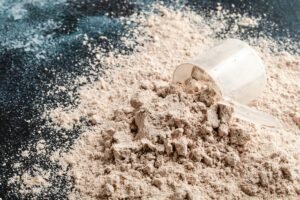 Scoop of Whey Protein in background. Sport nutrition.