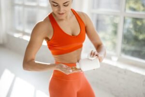 La Importancia de la Nutrición en el Rendimiento Deportivo. mujer con suplementos deportivos