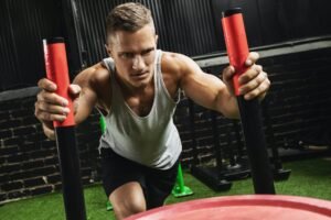 Estrategias para Desarrollar Fuerza y Potencia en tus Entrenamientos. Hombre haciendo el ejercicio de empujar el trineo